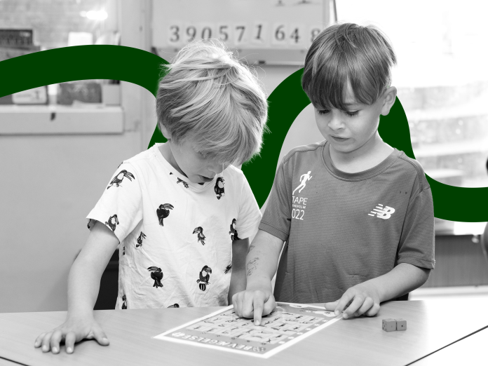 to små drenge kigger på et ark papir