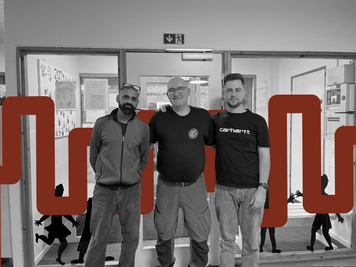 Tre mænd, der står sammen i en børnehave