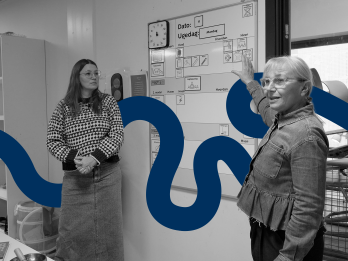 To mennesker, der står foran en tavle